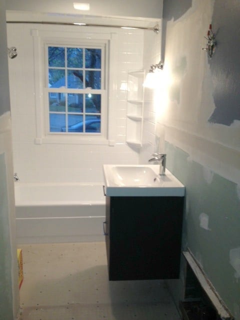 A bathroom with the recessed area now covered and a vanity and sink installed