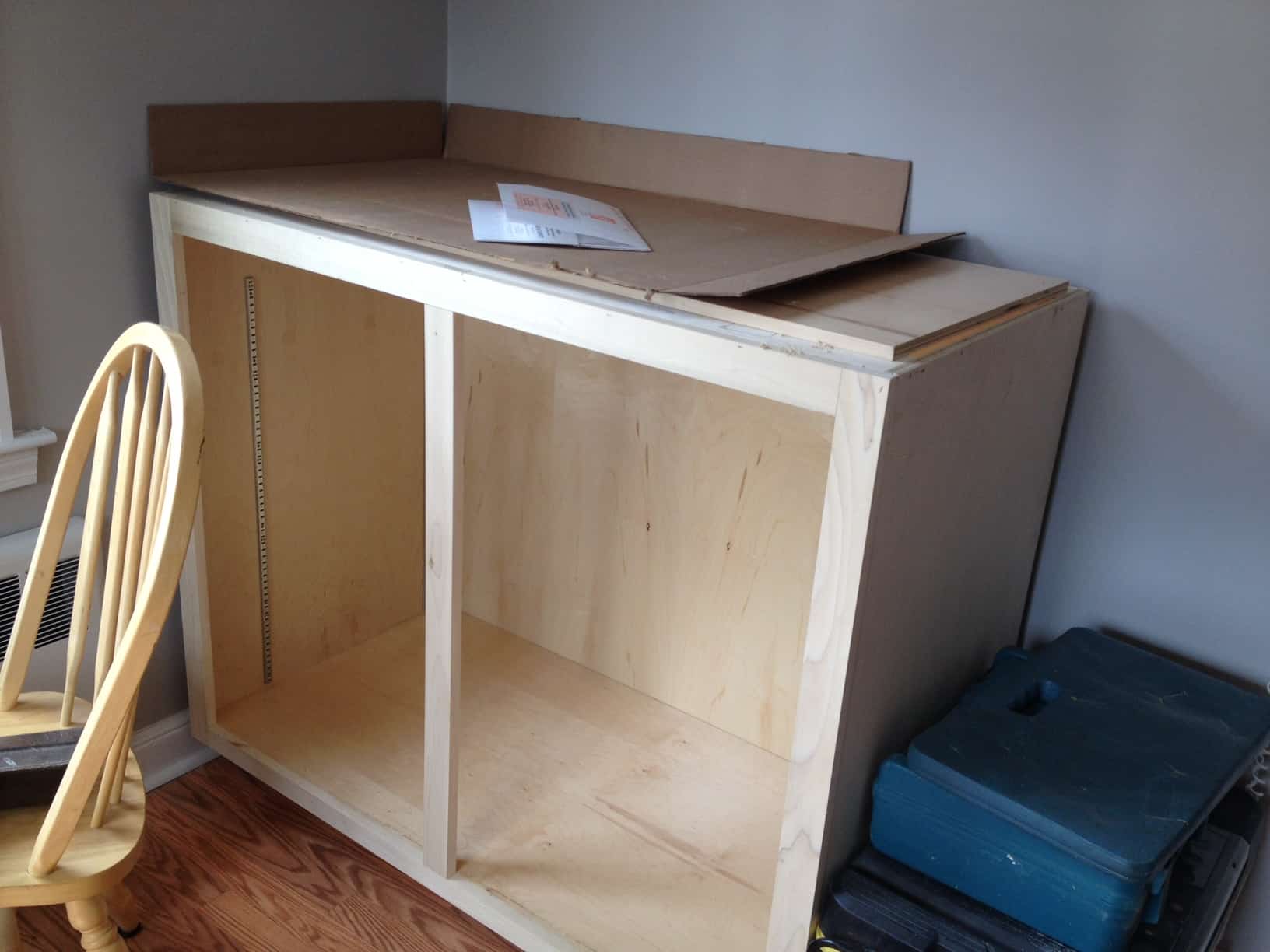 A cabinet, unpainted and unstained, and missing doors
