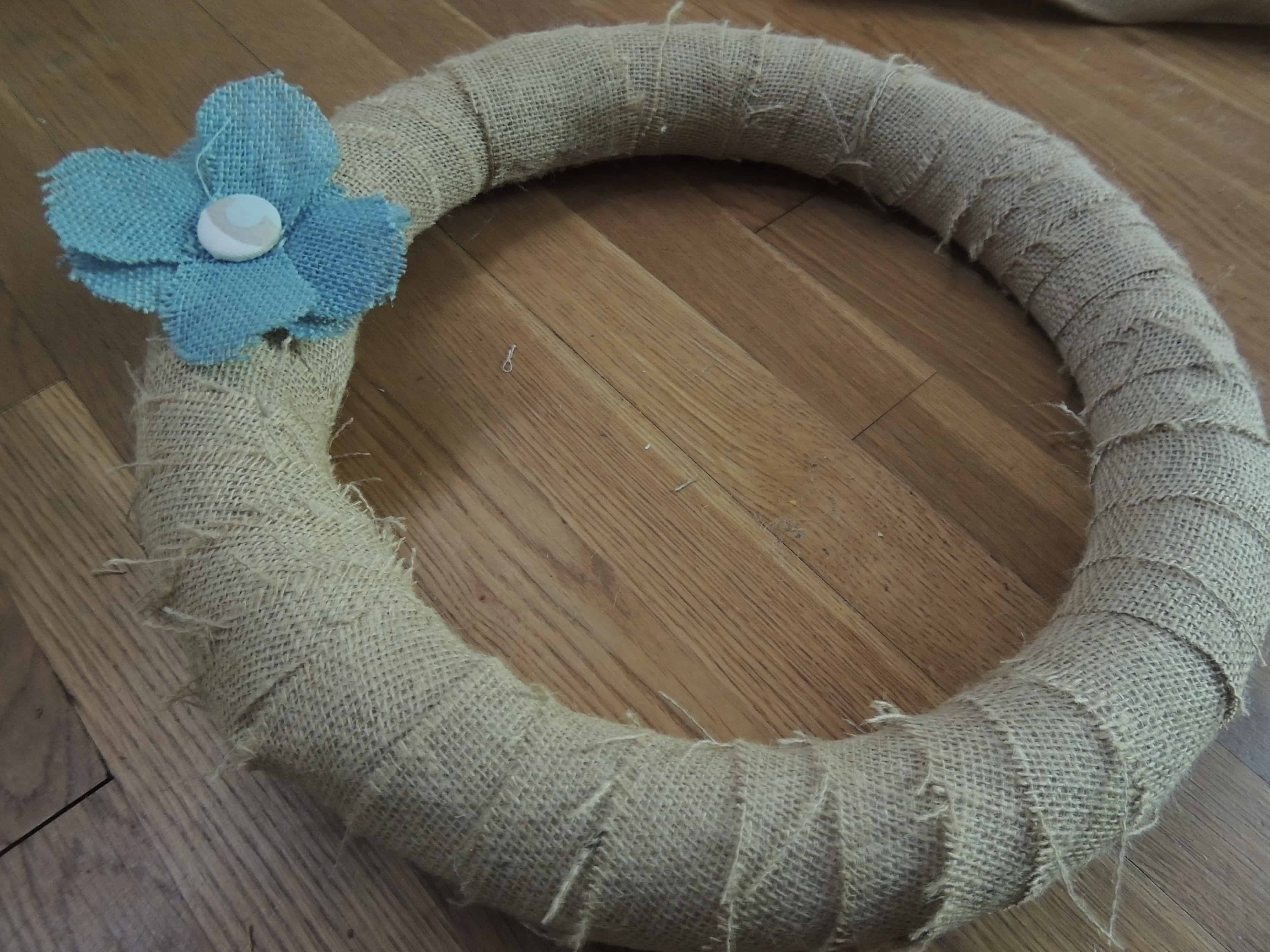  Attachez les fleurs de toile de jute à la couronne avec quelques gouttes de colle chaude 