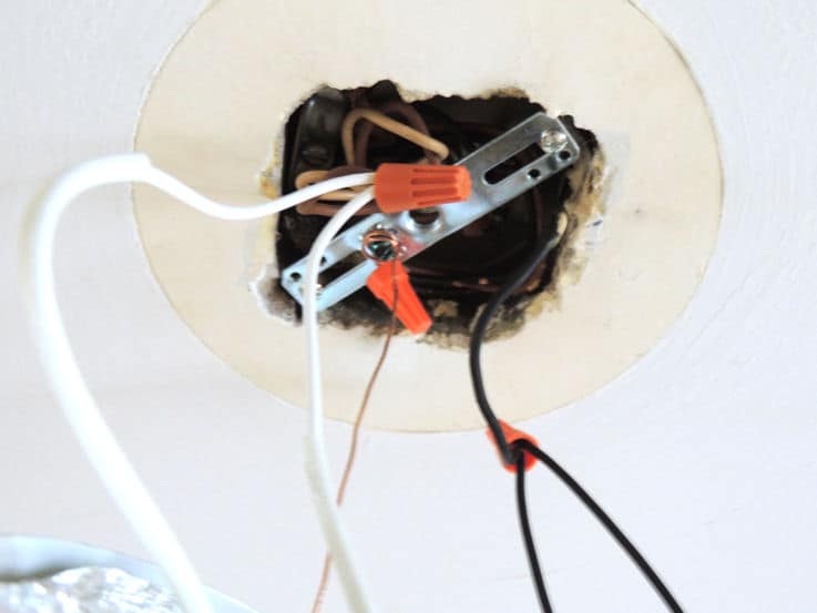Orange plastic caps covering electrical connections to old lighting fixture
