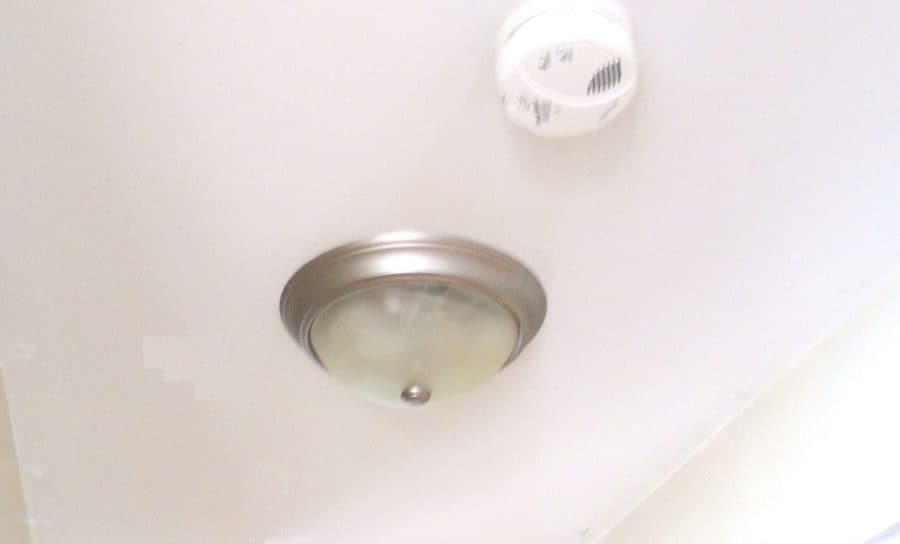 Silver, circular boob light on hallway ceiling.