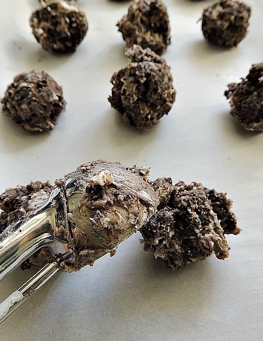 A cookie scoop forms the 1 inch oreo cookie balls
