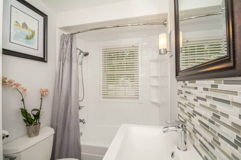 small bathroom with shower tub combo, and small vanity.