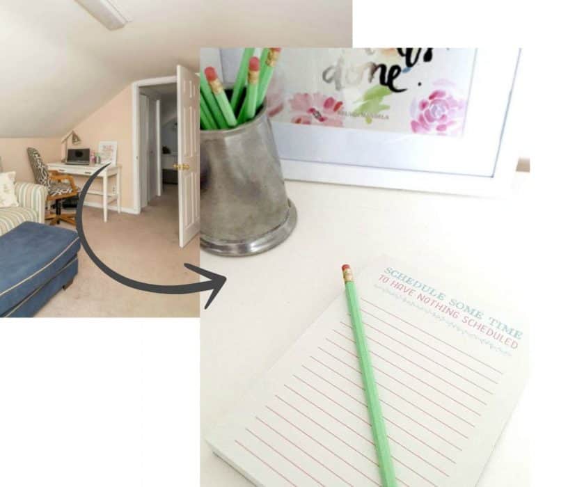 A desk top in the corner of a room, with a note pad, pencil, silver pencil holder with green pencils and framed art