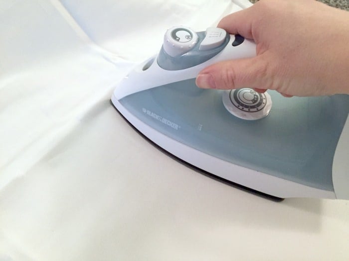 A person ironing a pillow case
