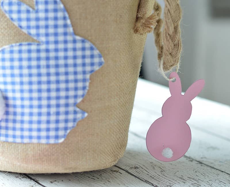 Pink paper Easter bunny hanging from the corner of a canvas Easter basket