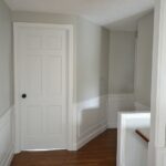 upstairs hallway with doors and wainscoting painted benjamin moore decorator's white