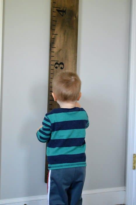 Young boy admiring height measurement on life size growth chart