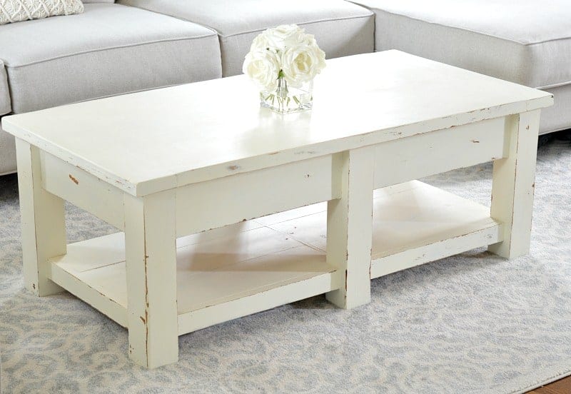 Rectangular coffee table, finished with cream-colored paint, with lower shelf underneath