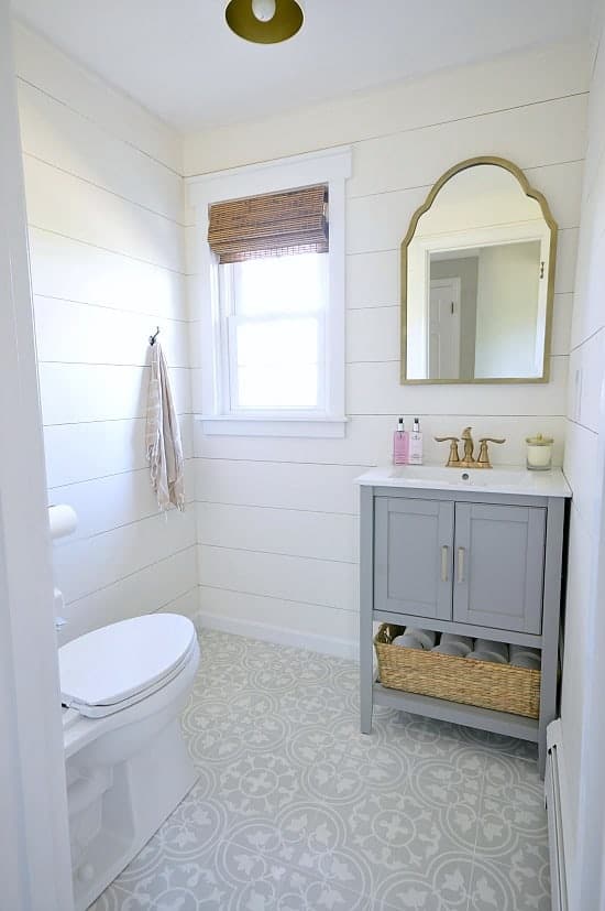 small bathroom with shiplap walls and cement tile floor.