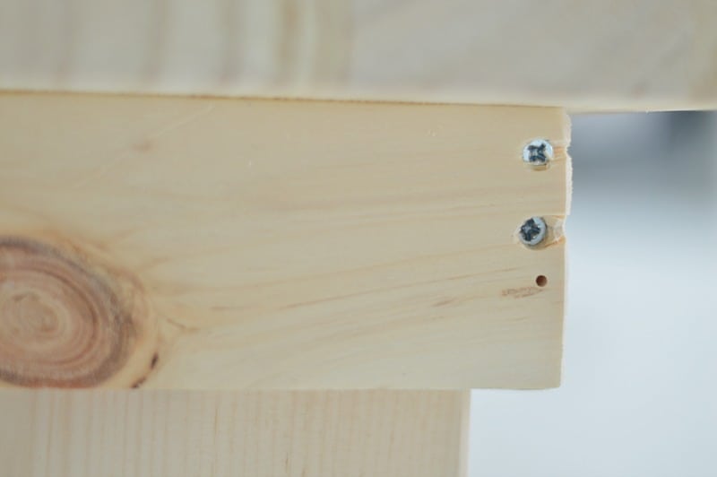 Side view of table, showing top of table, side and the screws indented in the pockets