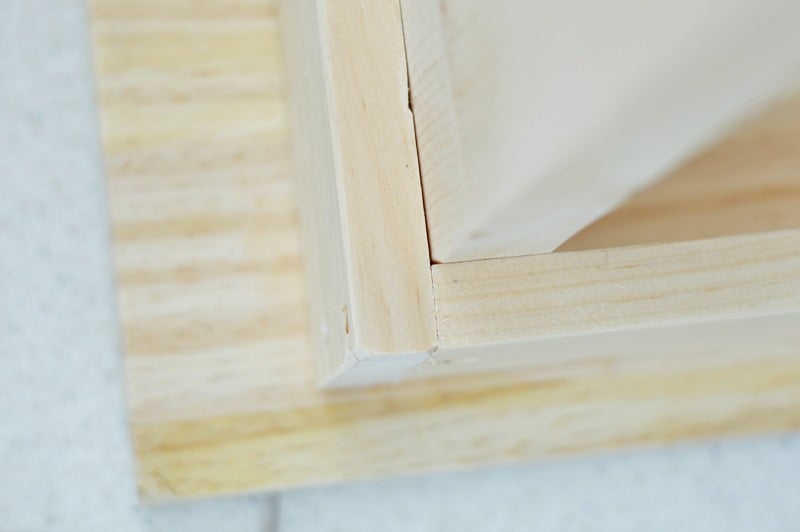 A close-up (underside) view of the three main wood pieces - the top of the table, with narrow side pieces and legs attached 