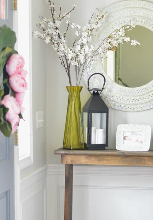 Close up of DIY console table in entryway, styled with various accessories
