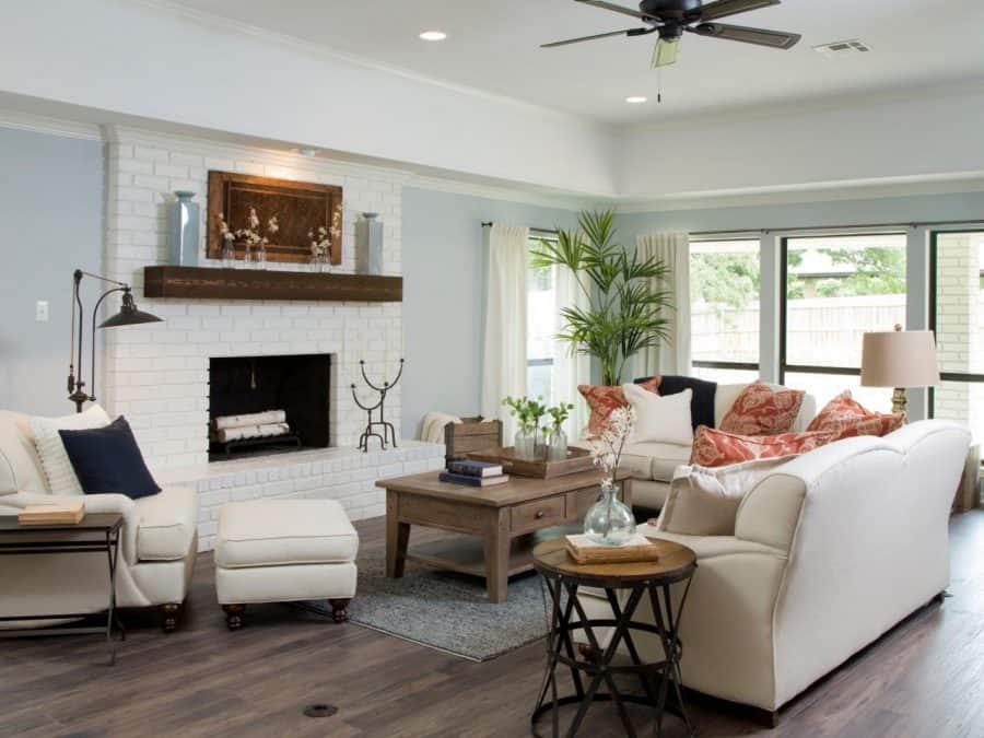 Farmhouse style living room with painted brick fireplace and rustic mantle