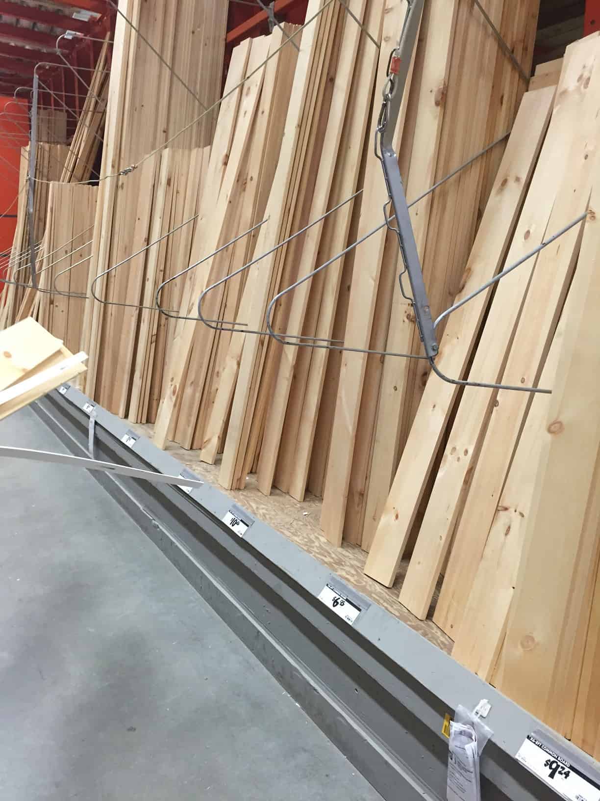 A shelf containing various planks of unpainted, unstained wood in a hardware store