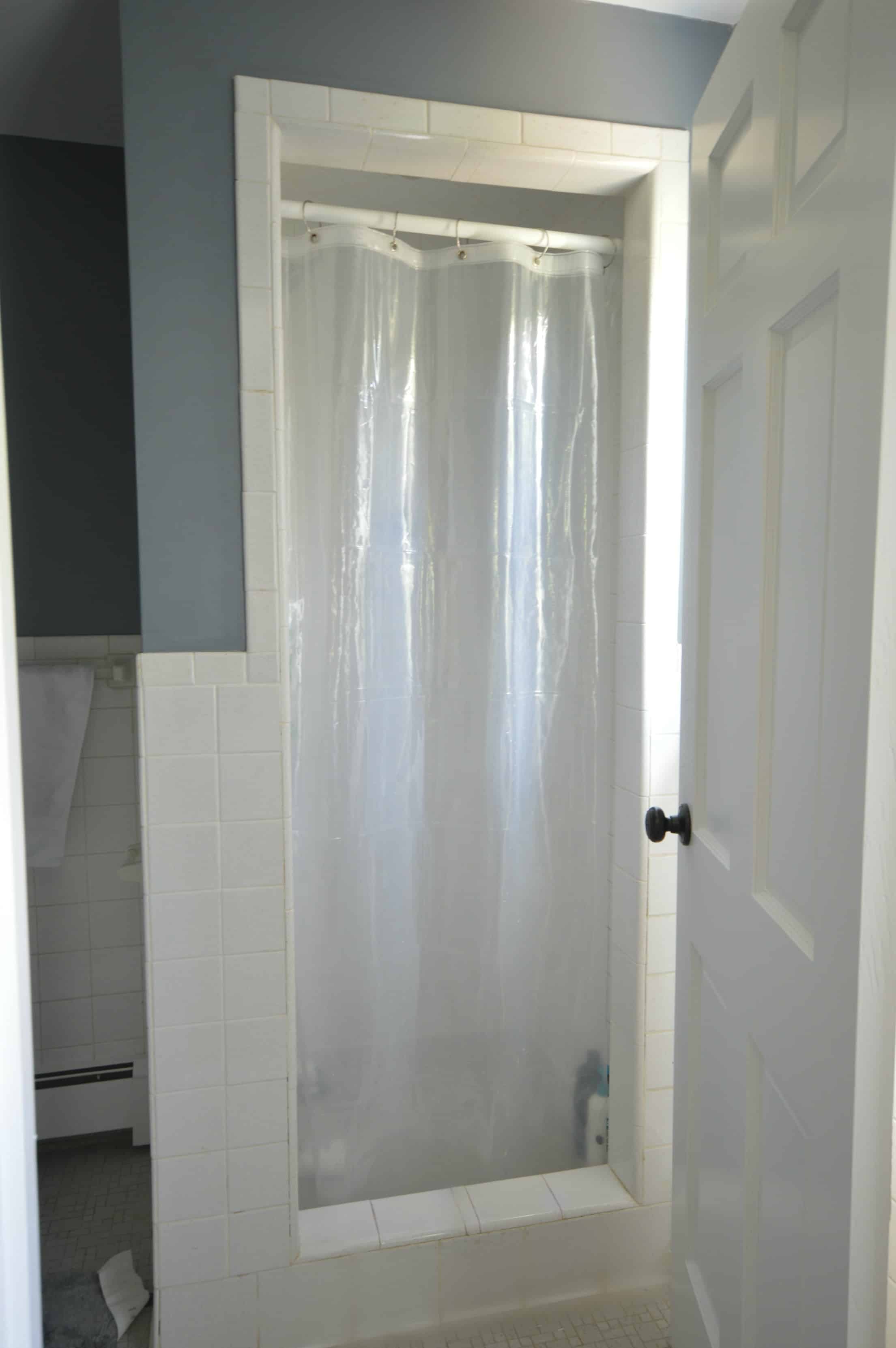 A stand-up shower with a clear, plastic shower curtain