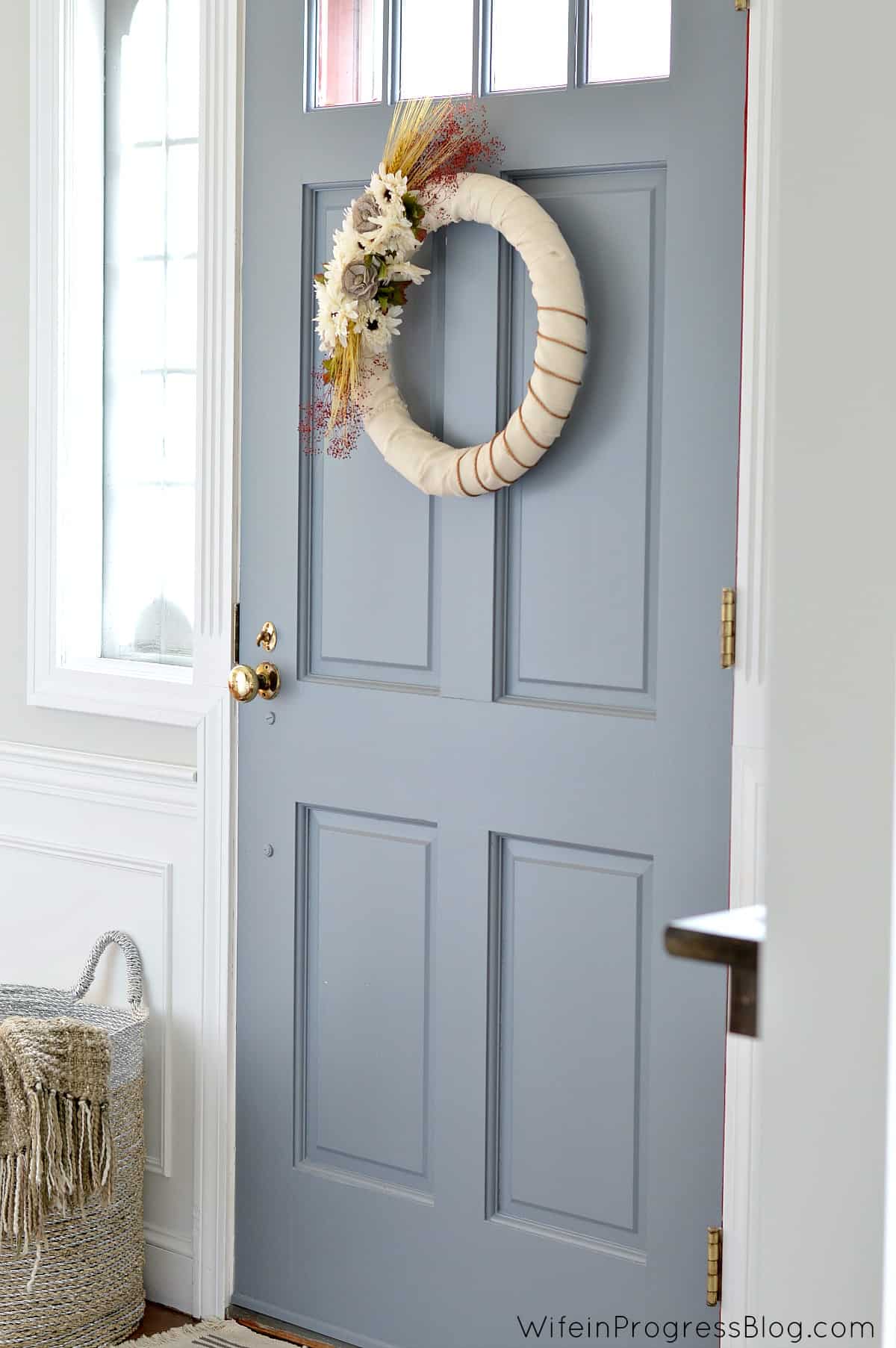 DIY fall wreath hanging on a blue door