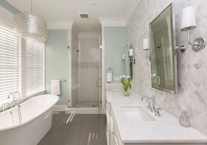 Elegant bathroom painted a soft gray green paint color with a relaxing soaking tub and walk-in shower