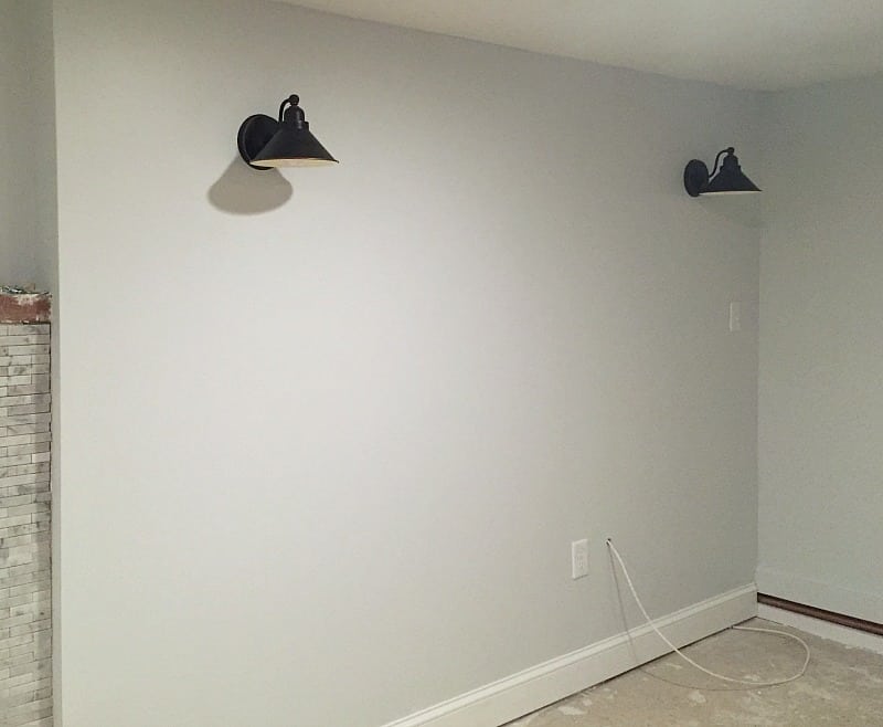 Two black wall-mounted lights on the new walls where wood paneling used to be