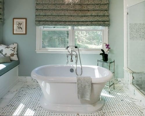 Master bathroom with large soaking tub in the middle and walls painted Quiet Moments with natural light seeking in. 