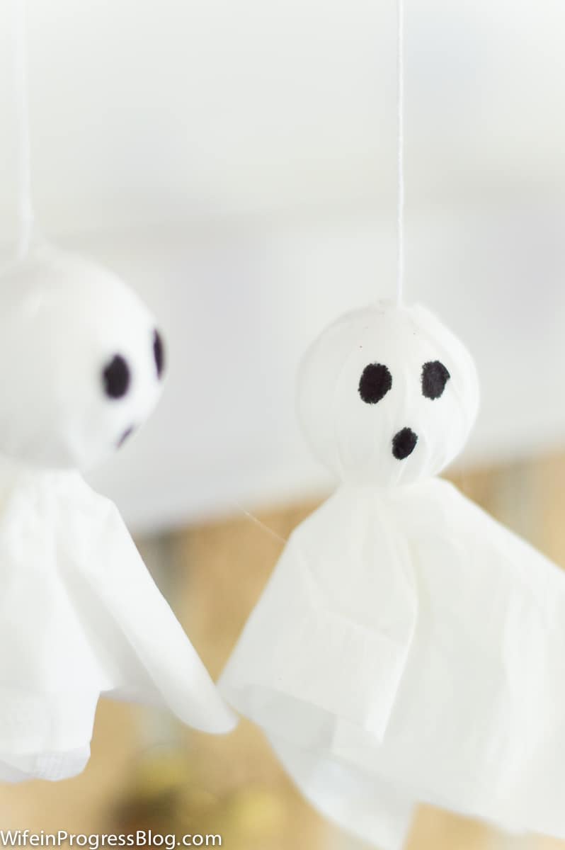 A close-up of two tissue garlands with black eyes and mouth