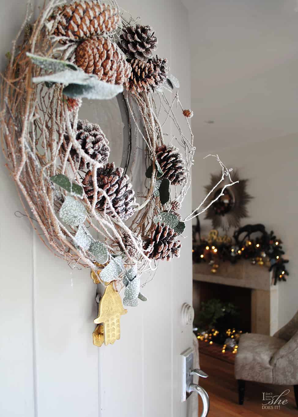 A rustic wreath made of wrapped branches, pine cones and frosted leaves