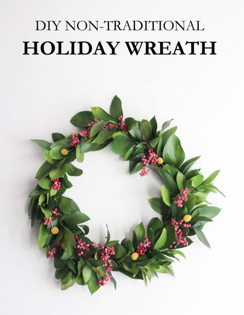 A wreath made from loose, green leaves and sprigs of berries