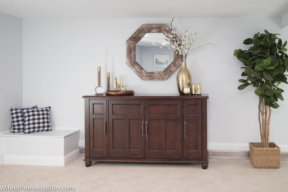 dark wood sideboard with a mirror and other decorative items 