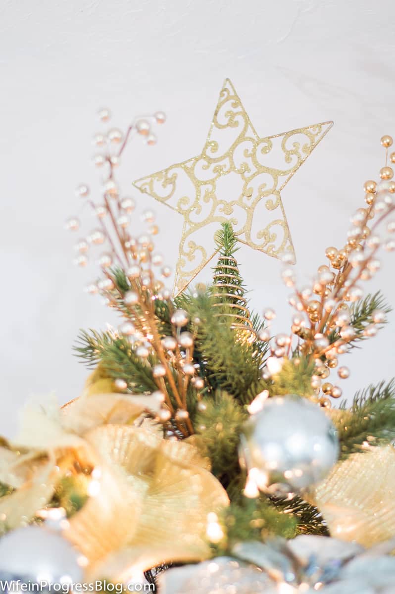 A close up of a golden star on top of a Christmas tree