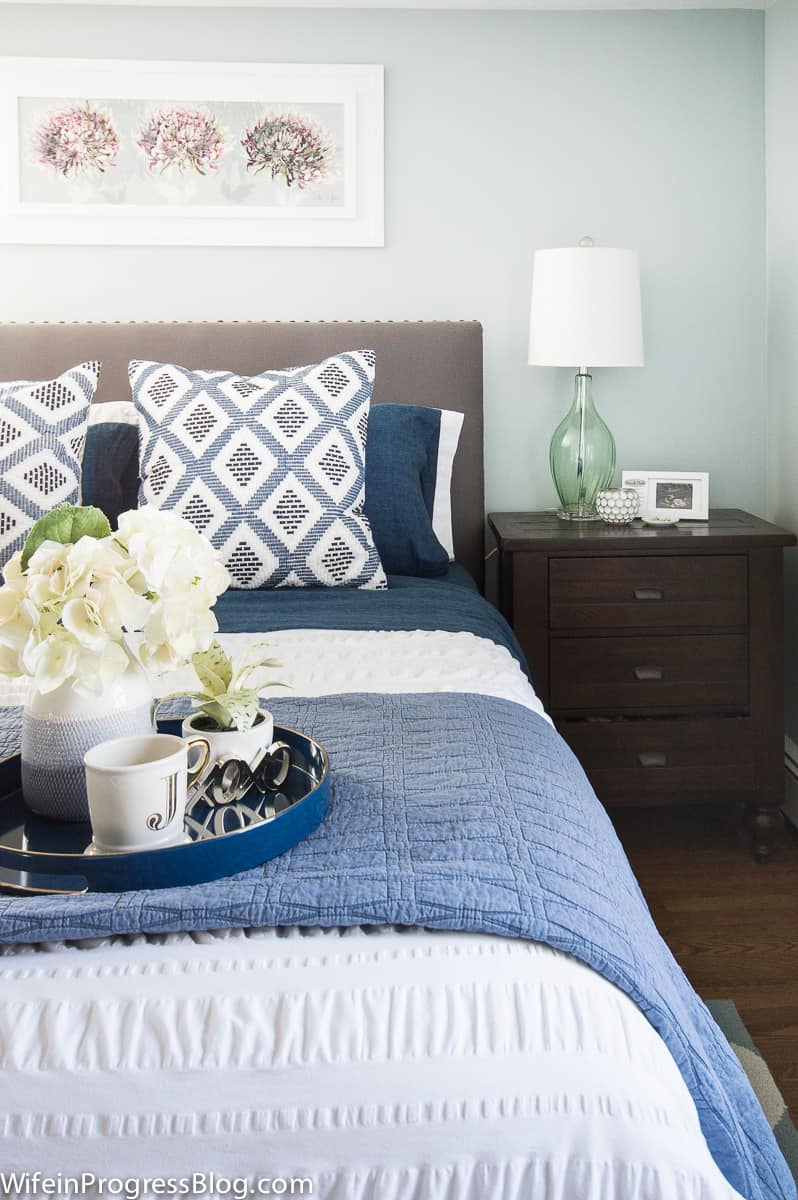 Soft blue bedding and bright flowers give warmth to this winter bedroom refresh