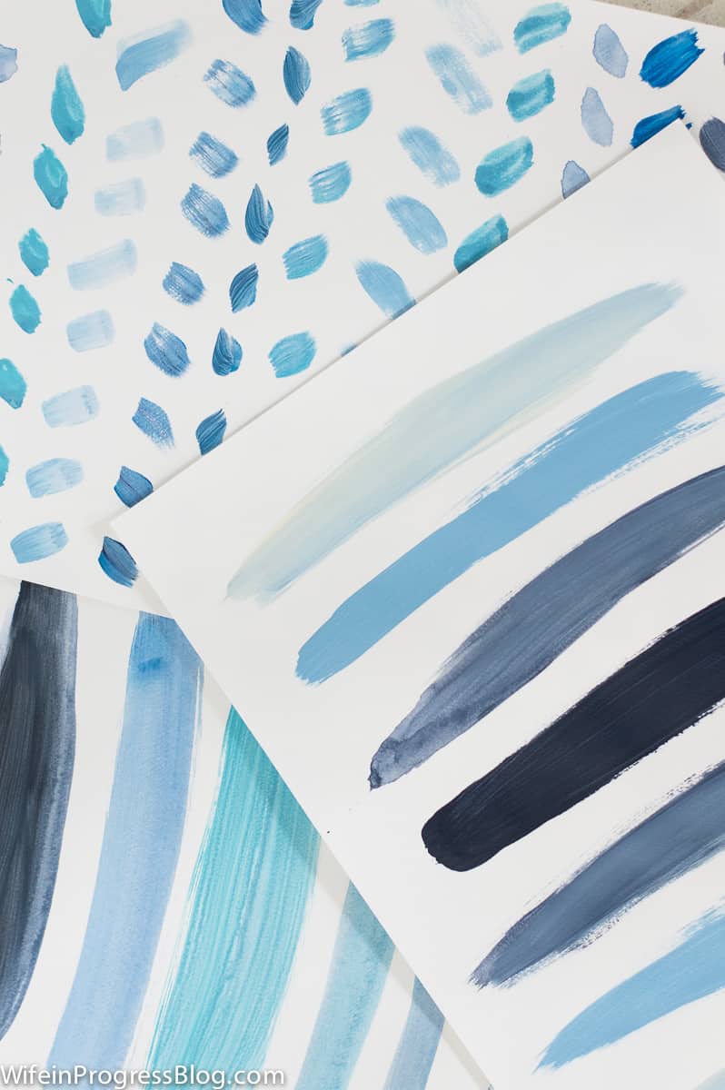 Three samples of different brush strokes (various blue shades) on white paper