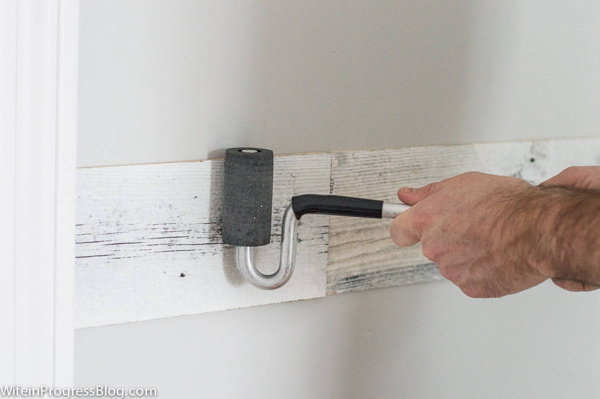 Rolling a paint roller over the planks to ensure adhesion