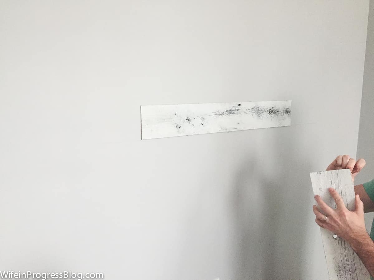 Installing stikwood on the wall, just peel and stick, once making sure it is level