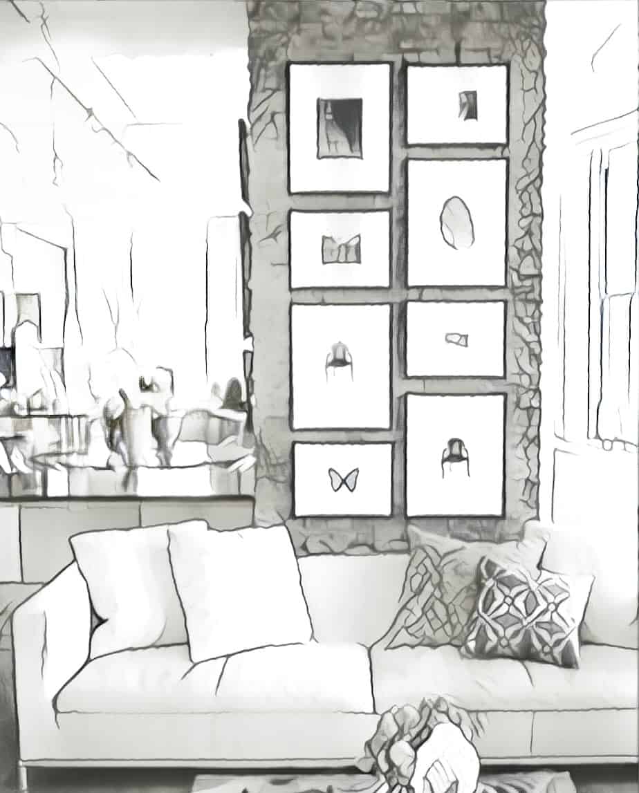 Sofa in living room with narrow stone wall in background, decorated vertically with frames of various sizes