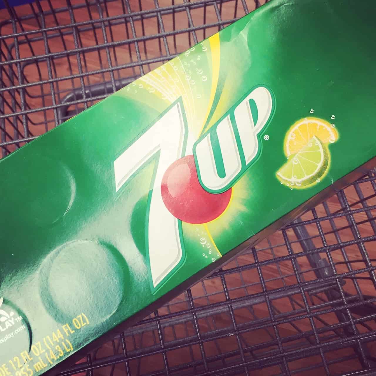 A large box of 7UP soda in a shopping cart
