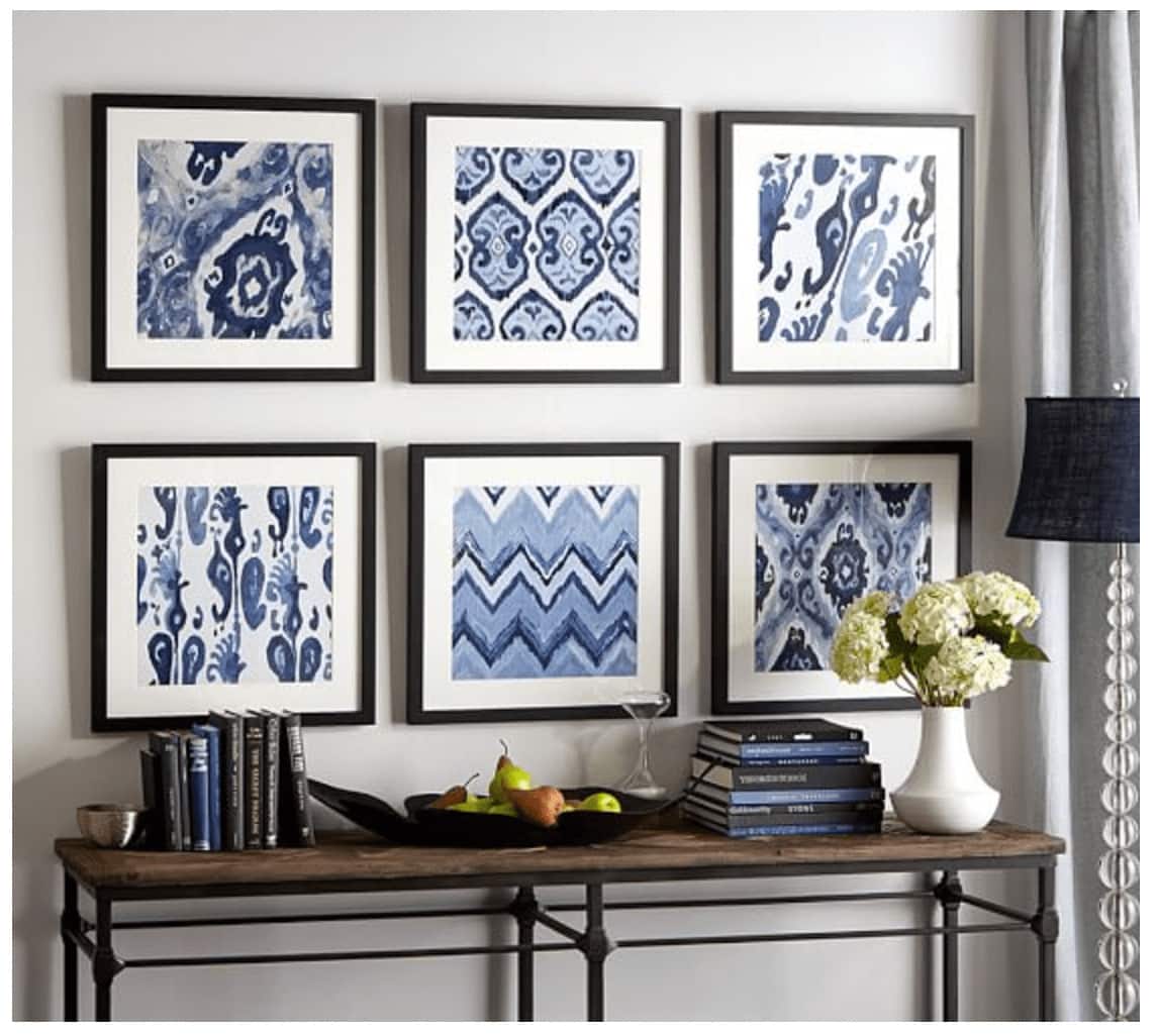 Gallery wall of abstract art over a console table in the living room