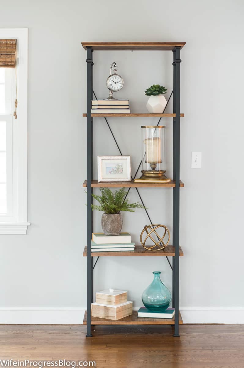 The original arrangement of items on bookcase, with taller items mixed with objects of various shapes and textures.