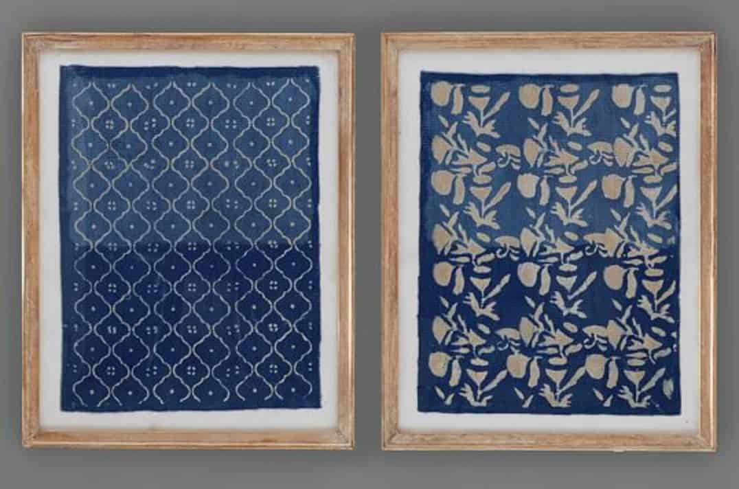 A pair of blue printed textiles in a large, light brown wooden frame (sold at Pottery Barn)