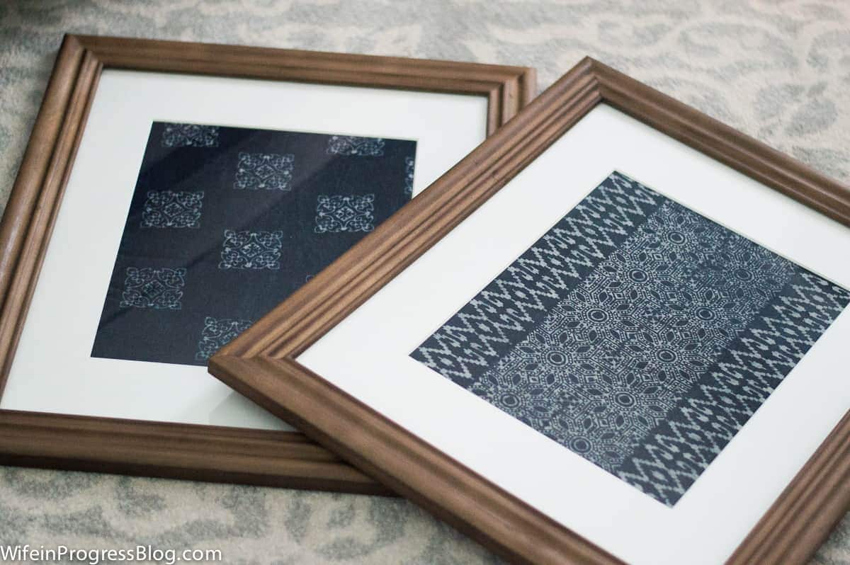 A close-up of the newly framed textile prints resting on the carpet before being hung