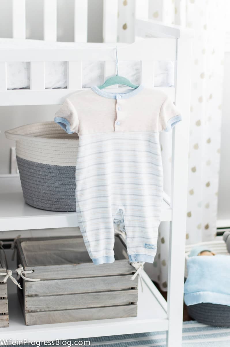 Baby boy onesie hanging on changing table in nursery