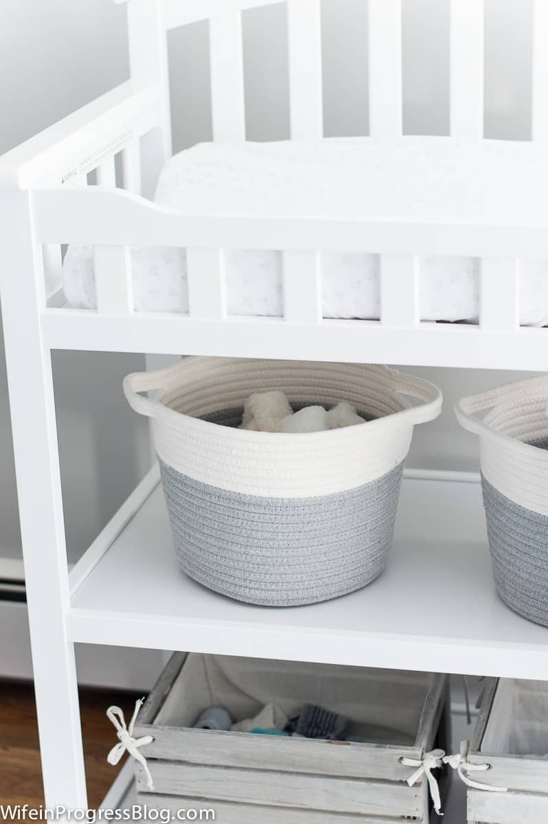 Grey and white storage bins in baby boy nursery