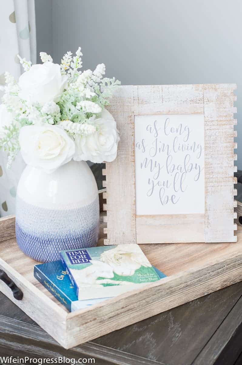 Rustic endurable with tray featuring wooden frame, flowers and books in baby boy nursery