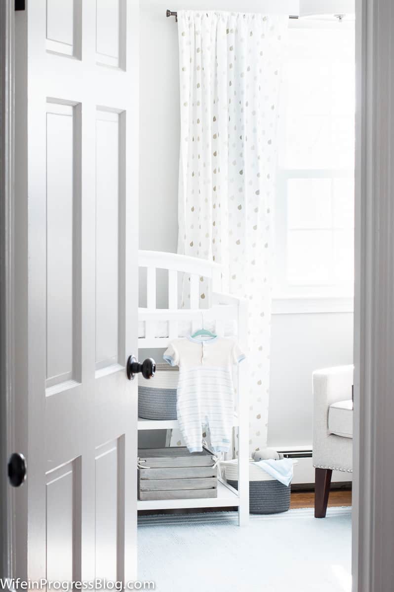 A stunning gray and blue baby boy nursery featuring a reclaimed wood accent wood.