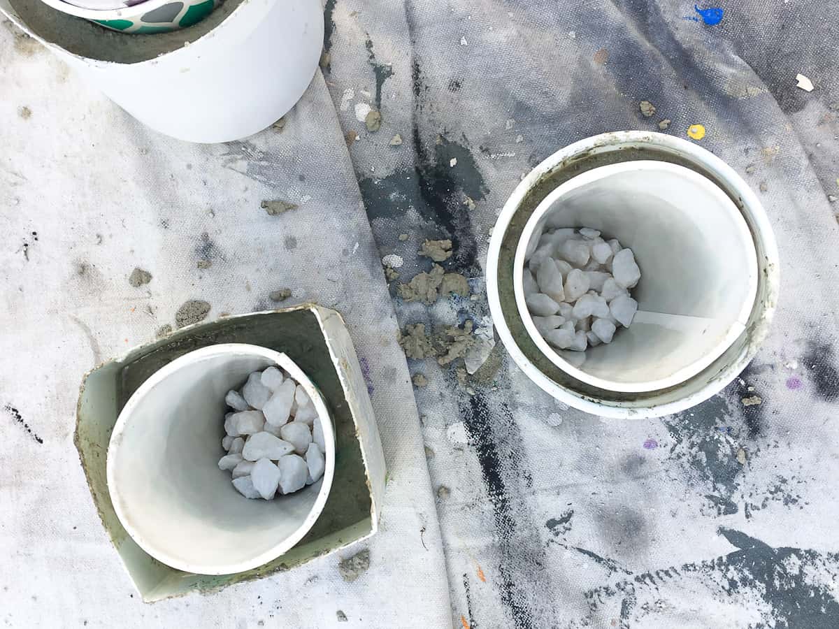 Adding a small amount of rocks to weigh down the inside container and set the shape of the concrete planter