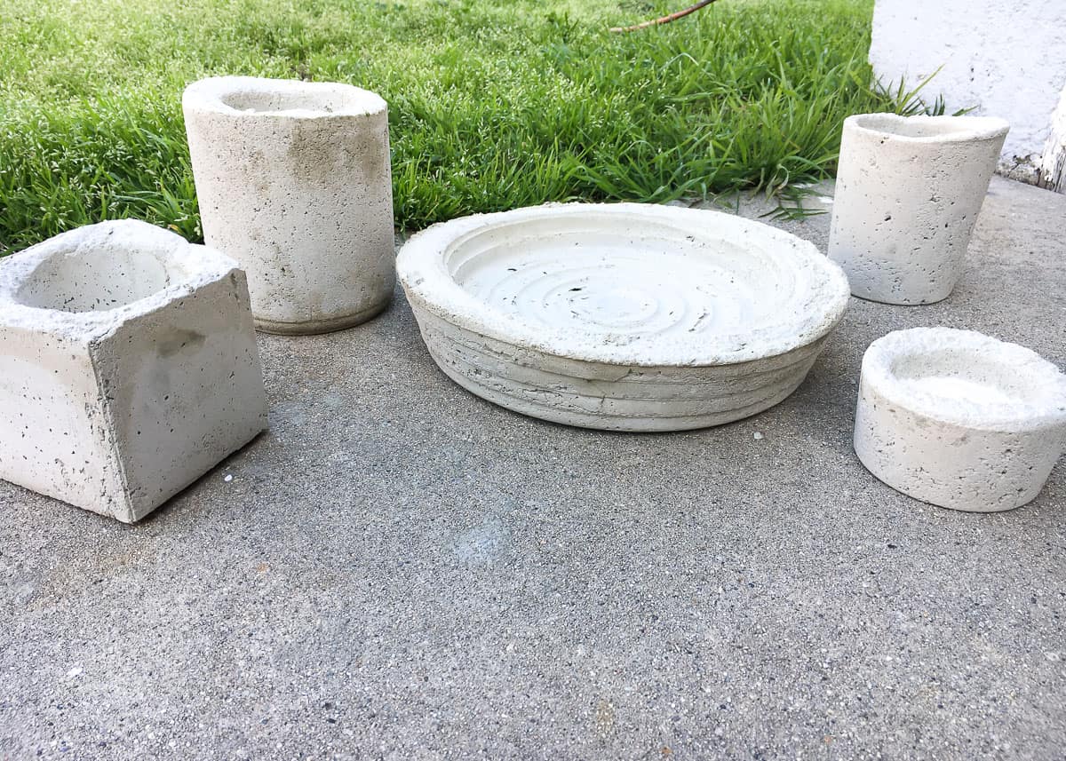 The freshly dried molds, separated from their plastic containers, sitting on a concrete patio, near a grassy area
