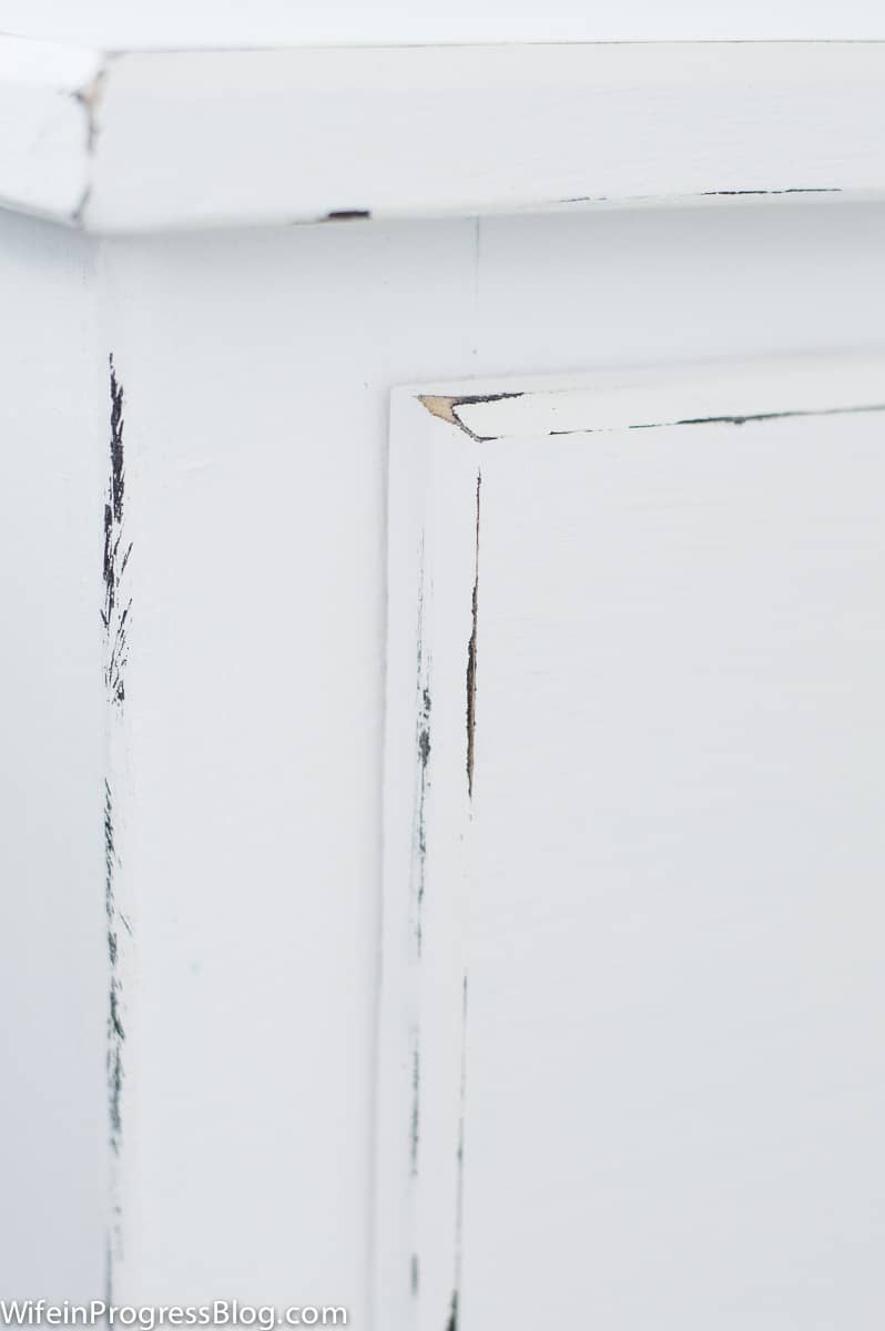 The nightstand, now painted with white chalk paint and distressed with sandpaper