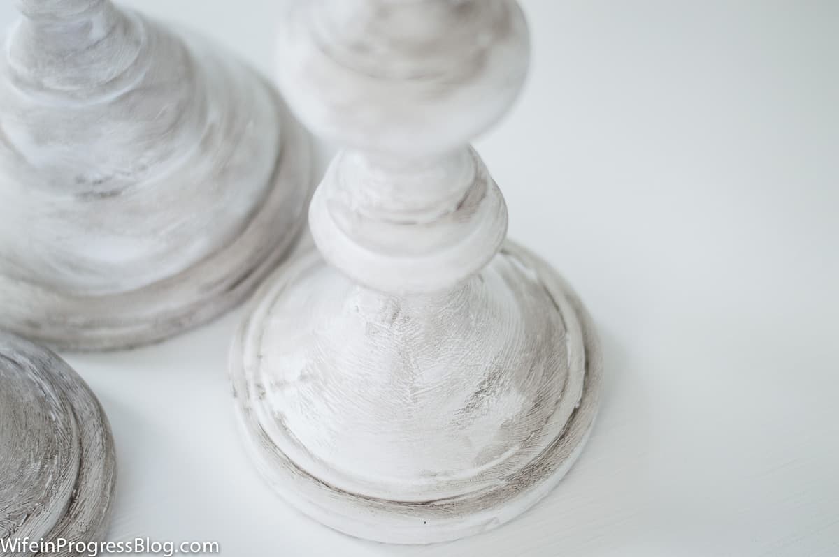 A close-up view of the effects of the antiquing wax on the white painted candles
