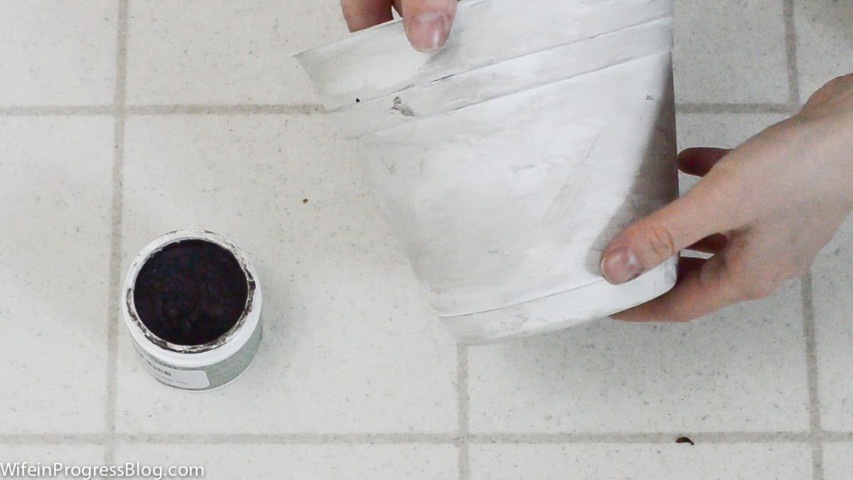 A plant pot, painted white, and now with an application of antiquing wax to make it look aged