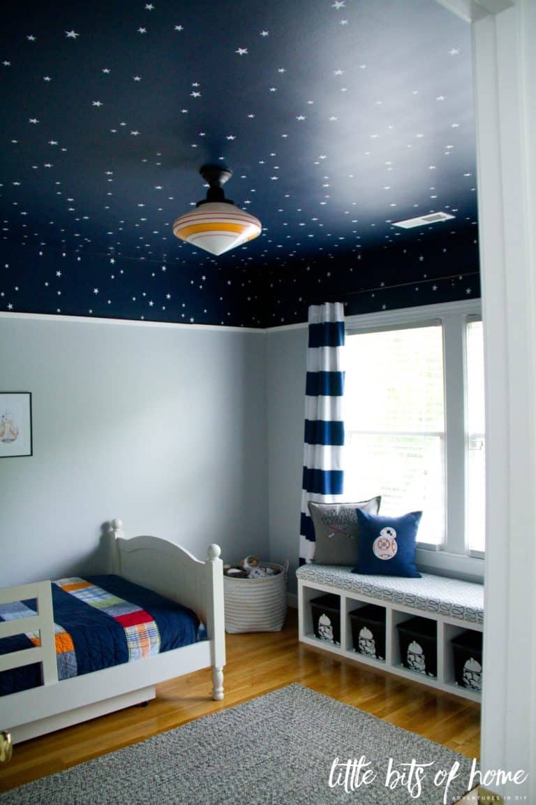 A navy blue ceiling with stars in a little boy room decorated in Star Wars theme.