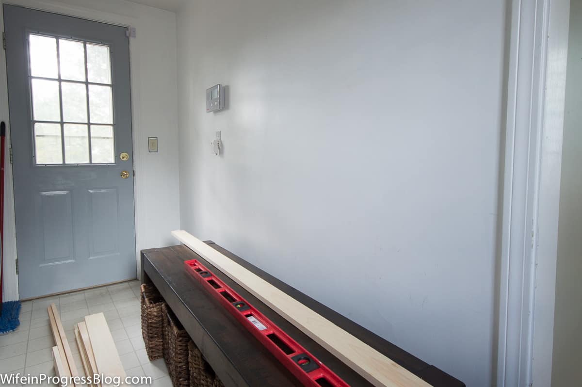 Our mudroom before we did our diy board and batten makeover. A narrow room with a dark, wooden bench with minimal personality.